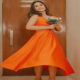 Glamorous look of Hina Khan in orange color dress, stylish pose with flowers in hand