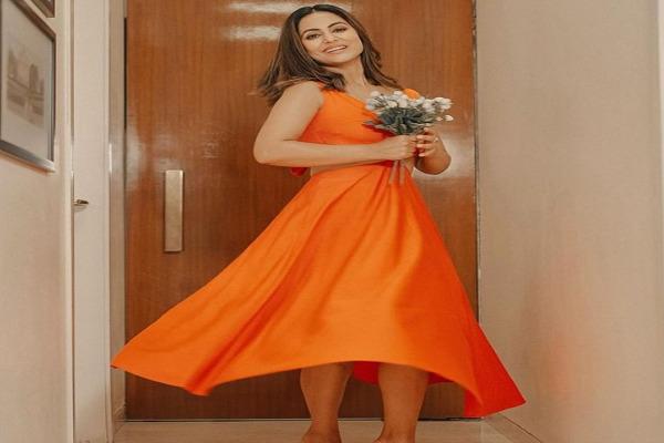 Glamorous look of Hina Khan in orange color dress, stylish pose with flowers in hand